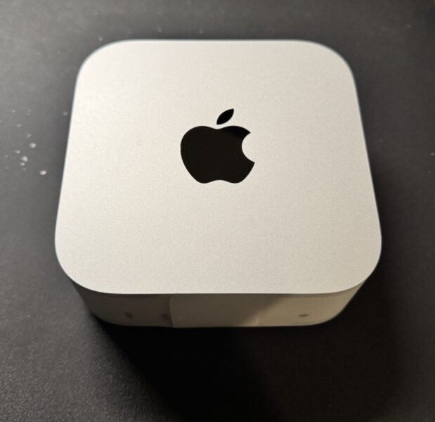 開封直後のMac mini M4 Pro本体。シルバーの筐体とAppleロゴのクローズアップ
