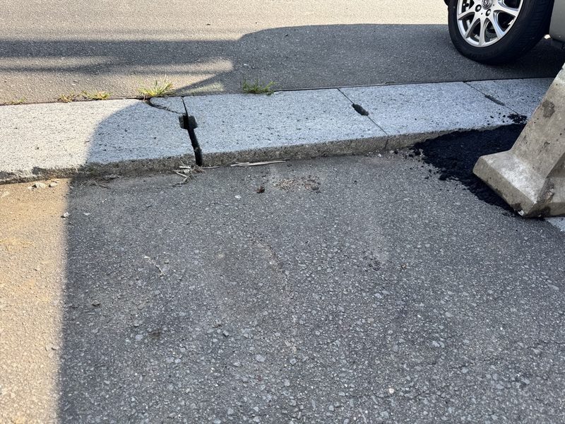歩道のコンクリートブロックが沈下して段差と鉄筋が飛び出した危険な状態のビフォー写真
